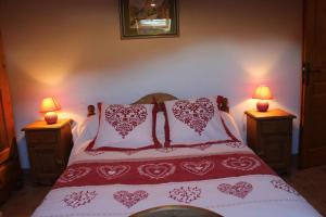 サモエンヌにあるLa Ferme de Sous-Lachatのベッドルーム1室(赤と白の枕が備わるベッド1台付)