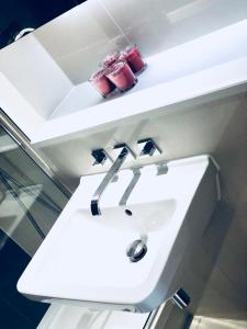 a white bathroom sink with a red purse on a shelf at Ultra Modern Room in London