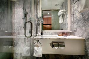 W łazience znajduje się prysznic i umywalka. w obiekcie Hougoumont Hotel Fremantle w mieście Fremantle