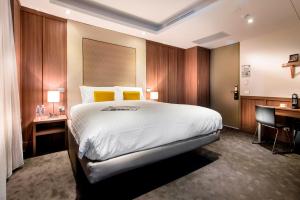 een hotelkamer met een groot bed en een bureau bij Hougoumont Hotel Fremantle in Fremantle