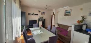 a living room with a table and a couch at Apartment Damir in Brodarica