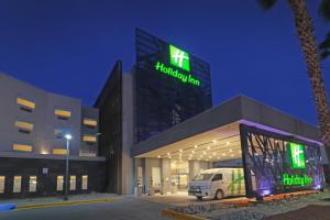 un edificio con una furgoneta estacionada frente a él en Holiday Inn - Ciudad Juarez, an IHG Hotel, en Ciudad Juárez