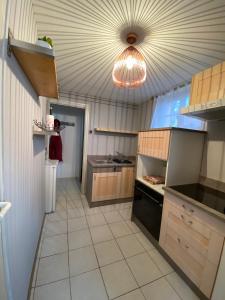 a large kitchen with a ceiling with a light at Le gîte du cavalier au cœur de la Forêt/jacuzzi in Dole