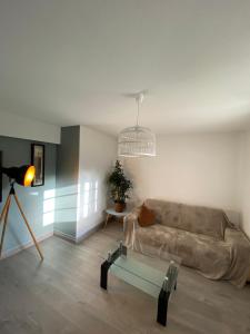 a living room with a couch and a glass table at Le gîte du cavalier au cœur de la Forêt/jacuzzi in Dole