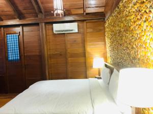 a bedroom with a bed in a room with wooden walls at Stung Treng Resort in Stœ̆ng Trêng