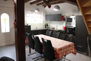 a kitchen with a table and chairs and a kitchen with a stove at Maison de Tante Louise in Mittelwihr