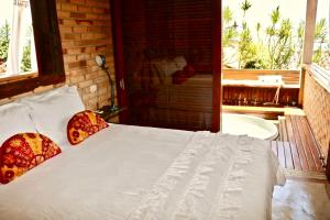 1 dormitorio con 1 cama y bañera en una habitación en Villa La Dolce Vita, en Ilhabela