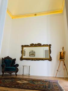 ein Wohnzimmer mit einem Spiegel und einem blauen Stuhl in der Unterkunft Beretti Home in Catania
