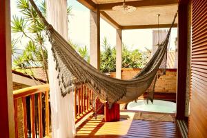 a hammock on the porch of a house at Villa La Dolce Vita in Ilhabela