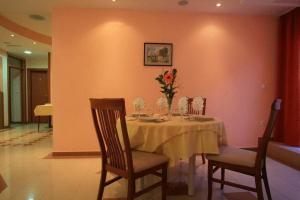 Una mesa de comedor con un jarrón de flores encima. en Hotel Leonardo, en Međugorje 18 fotos más