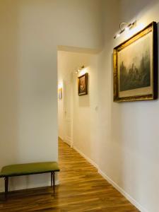 a hallway with a bench and a painting on the wall at Beretti Home in Catania