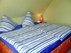 a bed with blue and white sheets and pillows at Zur Sonne in Freest