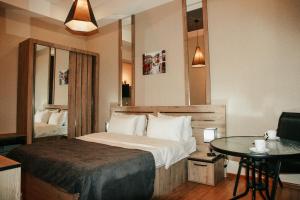 City Heart Hotel في تبليسي: غرفة الفندق بسرير وطاولة