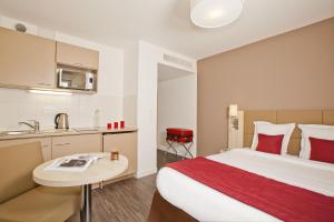 une chambre d'hôtel avec un lit et une cuisine dans l'établissement Residhome Nanterre La Défense, à Nanterre