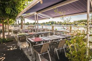 a group of tables and chairs with a view of the water at Les chambres de la Cotinière - Bord de Saône - St Jean de Losne in Saint-Jean-de-Losne