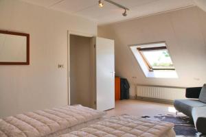 Pokój z łóżkiem, oknem i kanapą w obiekcie Appartement Abbestederweg Callantsoog w mieście Callantsoog