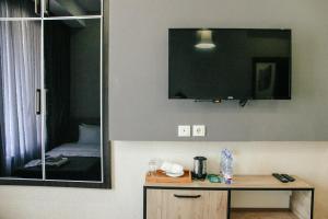 Habitación con escritorio y TV en la pared. en City Heart Hotel en Tiflis