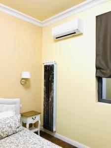 米蘭的住宿－Porta Ticinese Apartment，卧室配有一张床,墙上配有空调