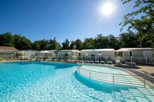 a large swimming pool in a apartment complex at Camping Les Chèvrefeuilles - Maeva in Royan