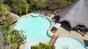 einen Blick über einen Pool mit Strohdach in der Unterkunft Sandy's Creations Resort in Lusaka + 38 Fotos