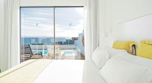 a bedroom with a bed and a balcony with a view at CalaLanzarote Suites Hotel - Adults Only in Playa Blanca +37 photos