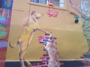 un perro y un perro jugando con una pintura en la pared en Palermo Viejo Bed & Breakfast en Buenos Aires