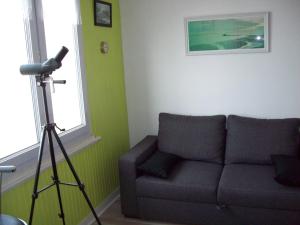 uma sala de estar com um sofá e uma câmara num tripé em Appt face mer em Le Portel