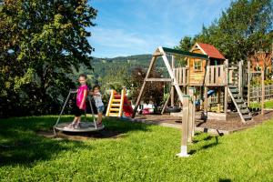 una niña y un niño en un patio de recreo en Hotel Friesacherhof, en Prebl