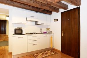una cucina con armadietti bianchi e forno a microonde di San Marco Loft a Venezia