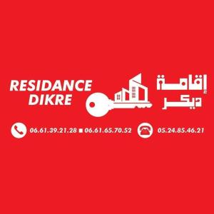 a red sign with a red background with a redance divide symbol at Résidence dikre in Ouarzazate
