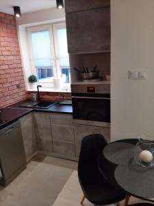 kuchnia z czarnym stołem i czarnym krzesłem w obiekcie Apartament Port w Ostródzie +22 zdjęcia