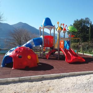 a playground with a slide and a ladybug play structure at Apartment Deki studio 2 in Kotor