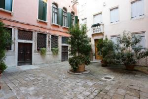 a courtyard with potted trees and buildings at San Marco Loft in Venice