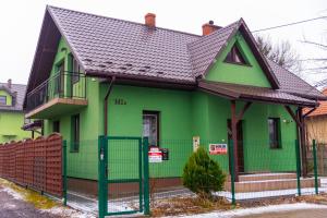 a green house with a black roof at RR pokoje in Kielce