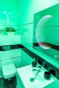 un bagno verde con lavandino e specchio di RR pokoje a Kielce