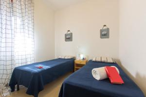 2 Betten in einem Zimmer mit blauer und roter Bettwäsche in der Unterkunft Appartamento La Pineta Nord - MyHo Casa in Martinsicuro
