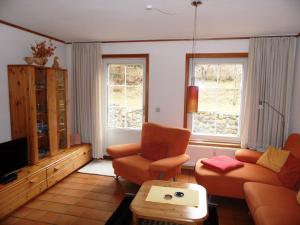 sala de estar con sofá, 2 sillas y TV en ökologische Ferienanlage en Heringsdorf