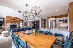 a kitchen and dining room with a wooden table and chairs at Les Falaises by Tremblant Platinum in Mont-Tremblant