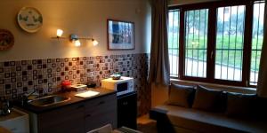a kitchen with a sink and a couch and a microwave at B&B GIRAMONDO in Castrovillari
