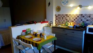 卡斯楚維拉里的住宿－B&B GIRAMONDO，厨房配有桌椅、桌子和柜台