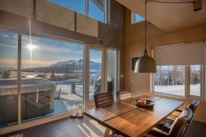 a dining room with a table and a large window at Viking Cottages & Apartments in Akureyri