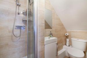 uma casa de banho com um chuveiro, um WC e um lavatório. em TH Serviced Apartment London em Northolt