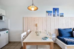 a living room with a table and a couch at Résidence Pierre & Vacances Cap-Morgat in Crozon +29 photos
