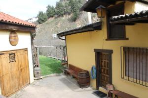 een gebouw met een bank naast een gebouw met een heuvel bij La Puchera in Cangas del Narcea