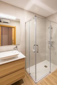 y baño con ducha acristalada y lavamanos. en Alameda Recalde Centro en Bilbao