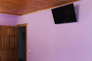 a tv on a purple wall in a room at La Puchera in Cangas del Narcea