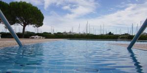 a swimming pool with blue water in a park at Brama Village in Aprilia Marittima