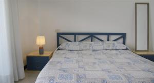 a bedroom with a bed with a blue and white quilt at Brama Village in Aprilia Marittima +36 photos