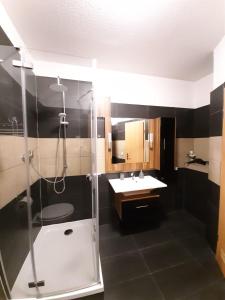 ein Bad mit einer Dusche und einem Waschbecken in der Unterkunft SAM - Gasthaus.MD in Magdeburg