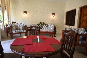 Un comedor con mesa y sillas en Tembo Court Apartment 164, en Malindi